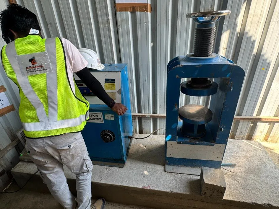 Compression testing machine crushing a concrete cube